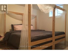A bed with a canopy and a striped pillow is in the image.