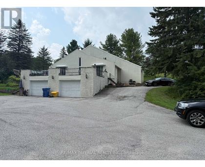 A white building with a garage door and a car parked in front.
