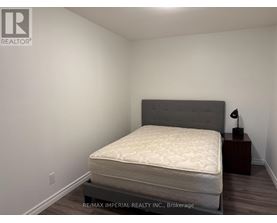 A bedroom with a bed, nightstand, and lamp.