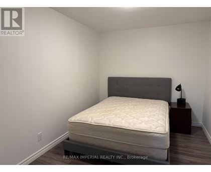 A bedroom with a bed, nightstand, and lamp.