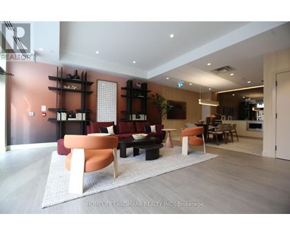 A living room with a white rug and a brown couch.