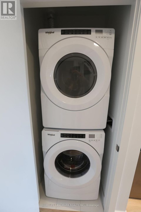 Two white Whirlpool washing machines in a cabinet.