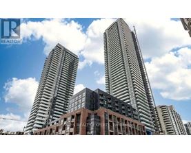 Two tall buildings stand behind a smaller building with a sign that says "REALTOR".