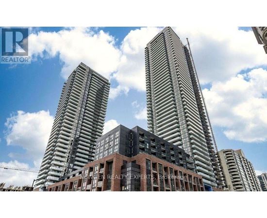 Two tall buildings stand behind a smaller building with a sign that says "REALTOR".