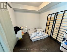 A bedroom with a bed, dresser, and wardrobe.