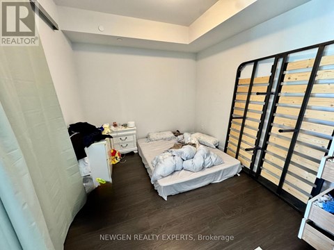 A bedroom with a bed, dresser, and wardrobe.
