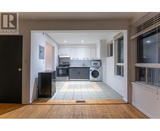 A modern kitchen with a black fridge and a black speaker.