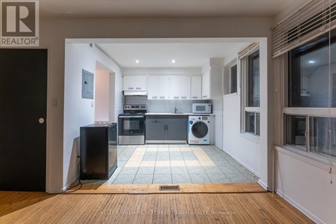 A modern kitchen with a black fridge and a black speaker.