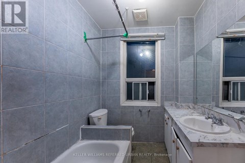 A bathroom with a toilet, sink, and tub.
