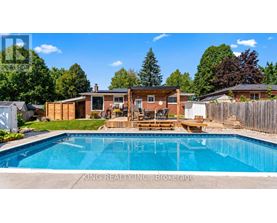 A pool in a backyard with a deck and a house in the background.