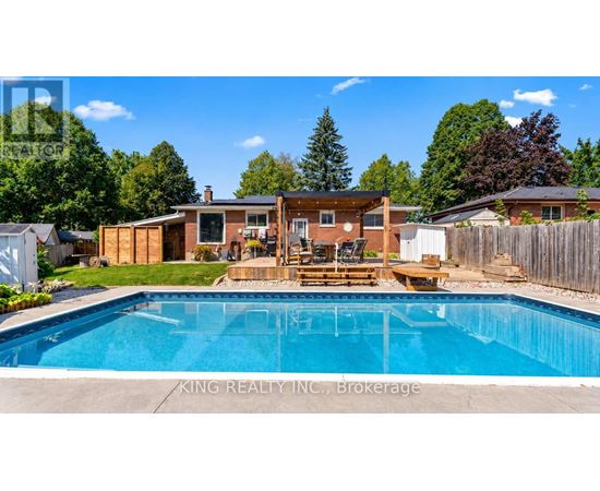 A pool in a backyard with a deck and a house in the background.