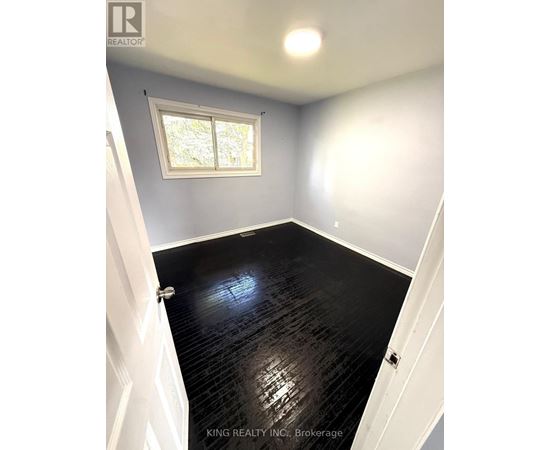 A room with a black floor and a window.