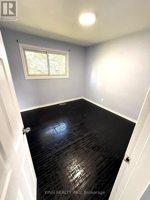 A room with a black floor and a window.