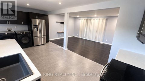 A kitchen with a sink, stove, and refrigerator.