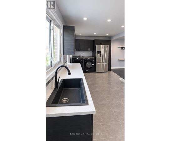 A modern kitchen with a sink and a refrigerator.