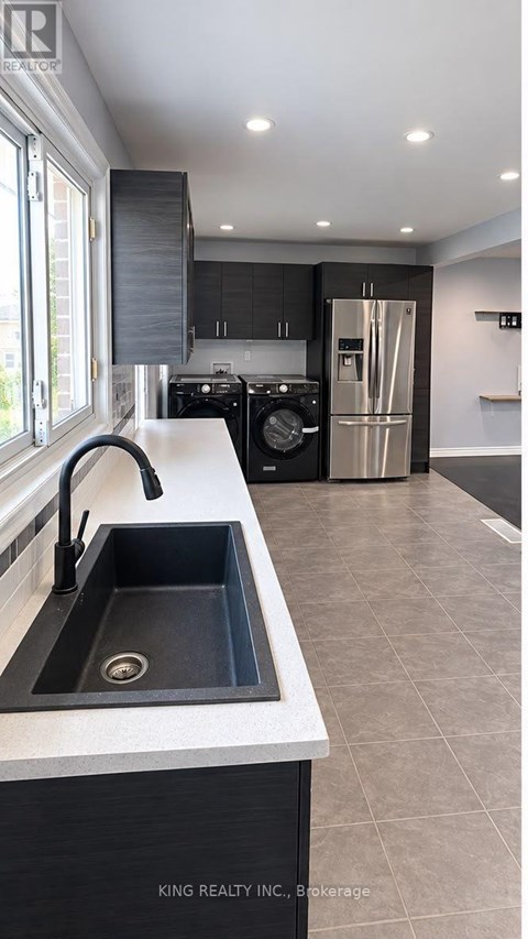 A modern kitchen with a sink and a refrigerator.