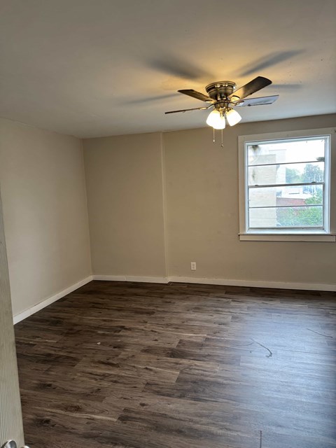A room with a ceiling fan and a window.