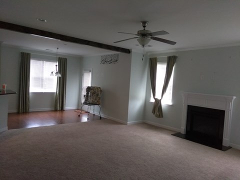 A living room with a fireplace and a fan.