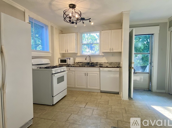 A kitchen with white appliances and cabinets.