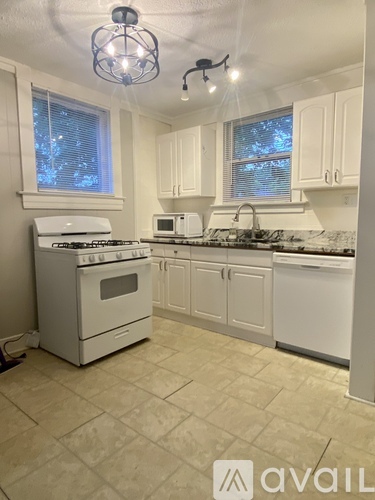 A kitchen with white appliances and cabinets.