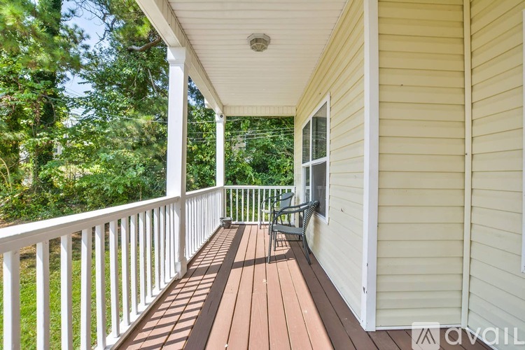 A porch with a bench and a view of trees.