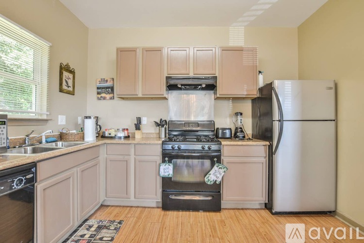 A kitchen with wooden floors and a black stove top oven.