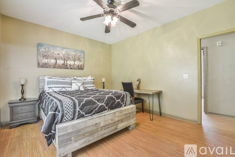 A bedroom with a bed, desk, and chair.