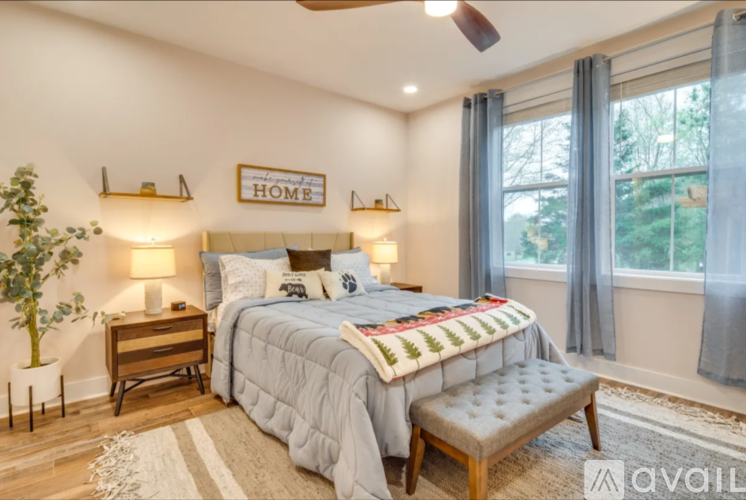 A bedroom with a bed, bench, and a ceiling fan.