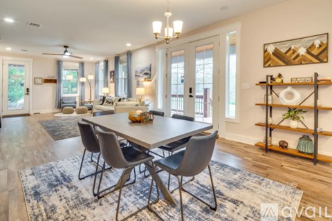 A dining room with a table and chairs set up.