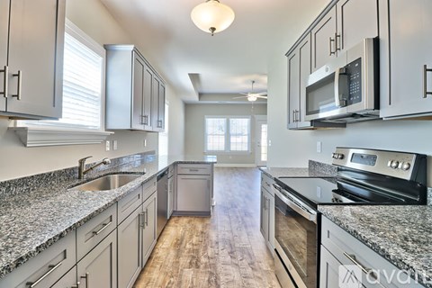 A kitchen with granite countertops and stainless steel appliances.