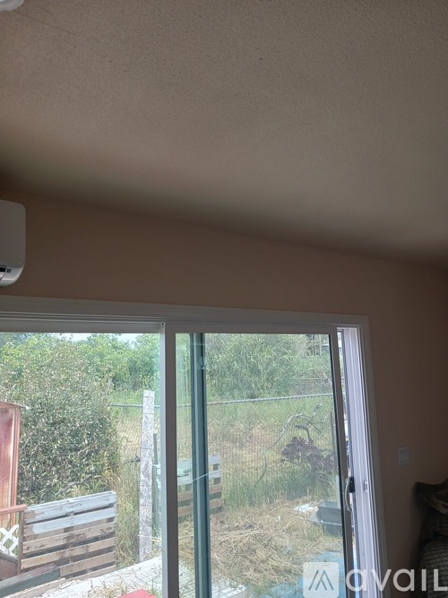 A room with a sliding glass door leading to a backyard.