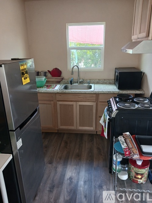 A kitchen with a refrigerator, sink, and oven.
