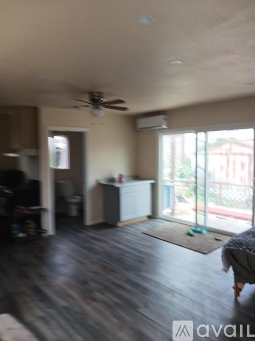 A living room with a ceiling fan and sliding glass doors.