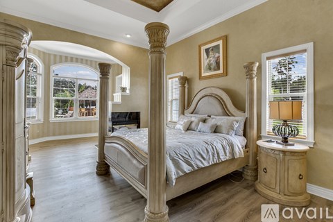 A large bedroom with a four poster bed and a balcony.
