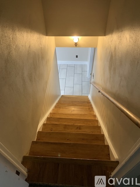 A wooden staircase leading to a white door.