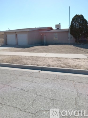 A house with a brown roof and white garage doors is for sale.