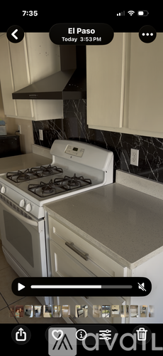 A white stove top oven with a black stove top is in a kitchen.