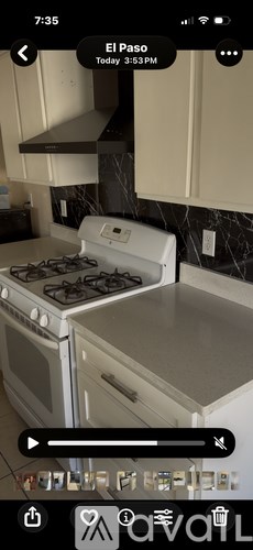 A white stove top oven with a black stove top is in a kitchen.