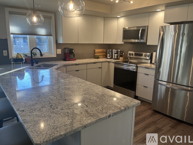 A kitchen with granite countertops and stainless steel appliances.