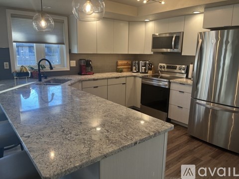 A kitchen with granite countertops and stainless steel appliances.