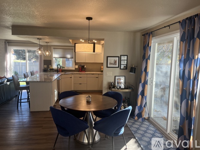 A dining room with a round table and blue chairs.