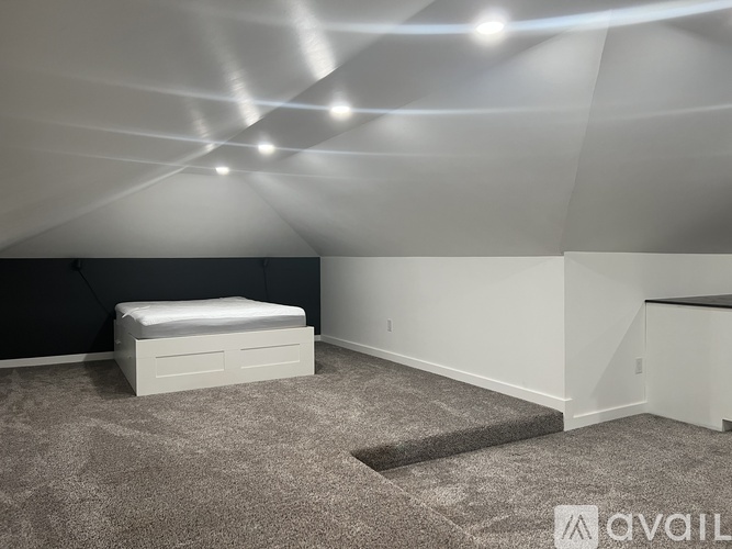 A bedroom with a bed, carpet, and a white ceiling.