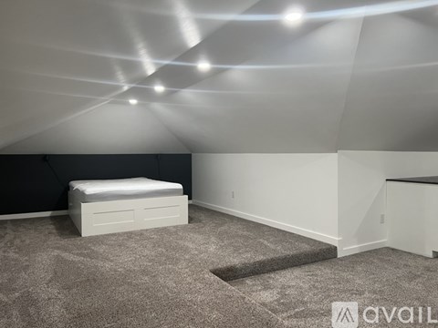 A bedroom with a bed, carpet, and a white ceiling.
