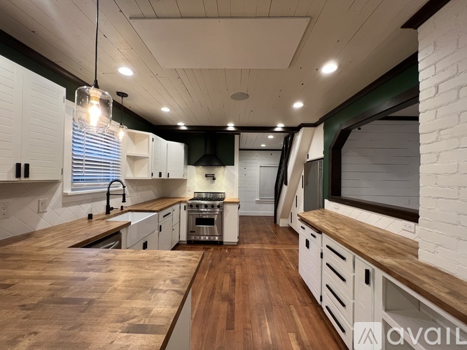A kitchen with a wooden table and white cabinets.
