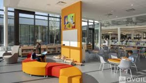 A brightly colored interior space with people sitting and standing.