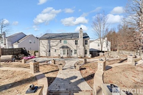 A house under construction with a brick pathway leading to the entrance.