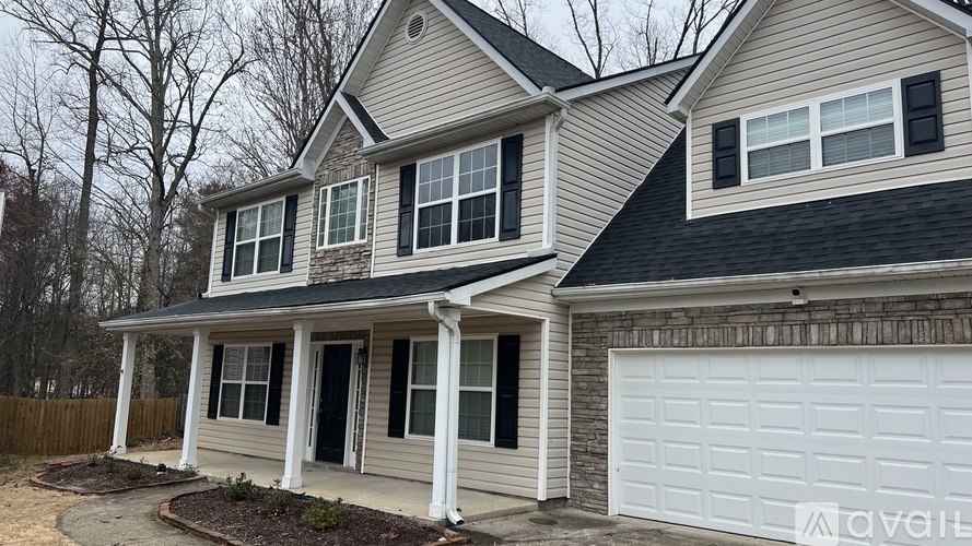 A two-story house with a white garage door.