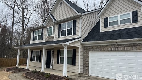 A two-story house with a white garage door.