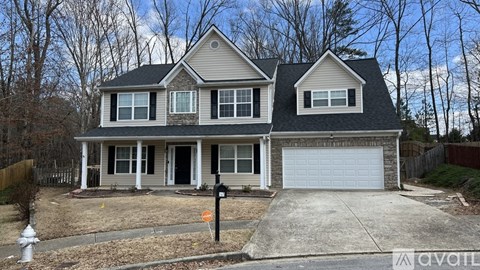 A house with a garage and a driveway in front.