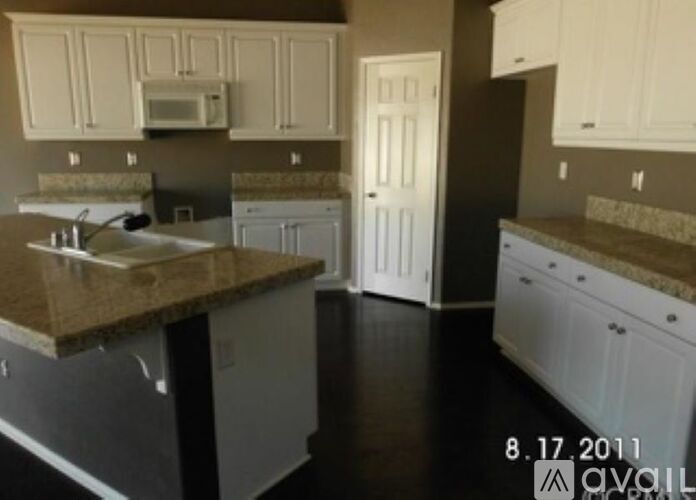A kitchen with white cabinets and granite countertops.